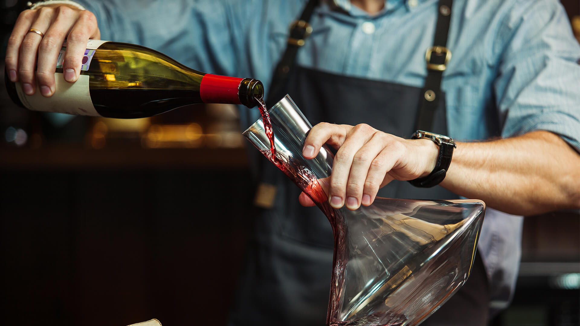 Wine being poured into a wine decanter 